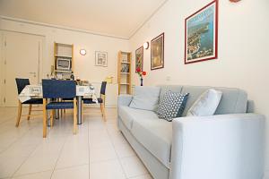 ein Wohnzimmer mit einem Sofa und einem Tisch in der Unterkunft Riva Lago e Spiaggia Apartment 3 in Riva del Garda