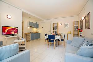 ein Wohnzimmer mit einem blauen Sofa und einer Küche in der Unterkunft Riva Lago e Spiaggia Apartment 3 in Riva del Garda