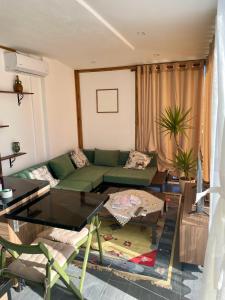 een woonkamer met een groene bank en een tafel bij Beus home in Durrës