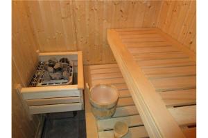 a small sauna with a stove and a trash can at Forester's Hut With Whirlpool & Sauna - Happy Rentals in Dol pri Hrastniku
