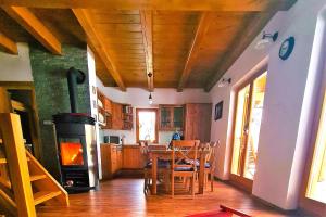 cocina con mesa y estufa de leña en Forester's Hut With Whirlpool & Sauna - Happy Rentals, en Dol pri Hrastniku