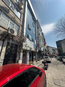 um carro vermelho estacionado numa rua ao lado de um edifício em Kadıköy Bull Hotel em Istambul