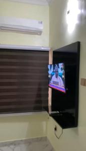 a flat screen tv on a wall in a room at LA VIVA AIRBNB in Abuja