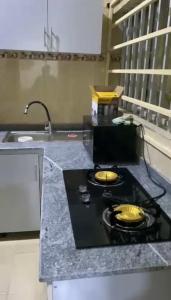 a kitchen counter with two frying pans on a stove at LA VIVA AIRBNB in Abuja