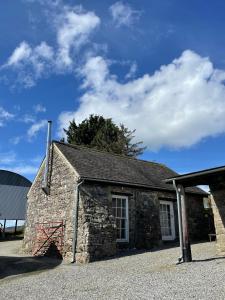 an old stone building with a blue sky at Lionhart Wellness Mountain Farm in Piltown