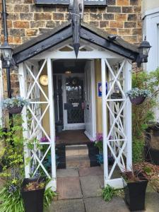 uma entrada para uma casa de tijolos com uma porta branca em Station Guesthouse em Lancaster