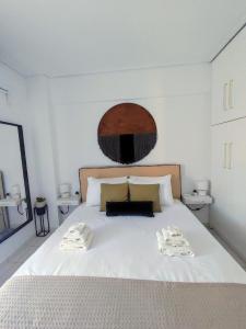 a bedroom with a white bed with two towels on it at Casa Di Penny in Kyparissia