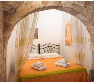a bedroom with a bed with towels on it at Trullo Masiello in Putignano