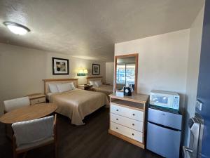 a hotel room with two beds and a television at Economy Inn in Reedsport
