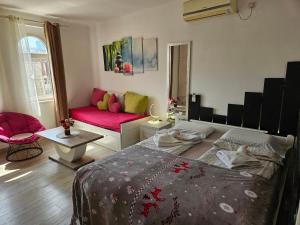 - une chambre avec un lit et un canapé rouge dans l'établissement Matea apartman, à Belgrade