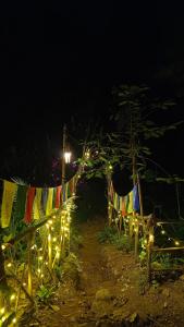a string of flags and lights on a fence at night at Triloka Dorm by The Offbeat Crew in Munnar