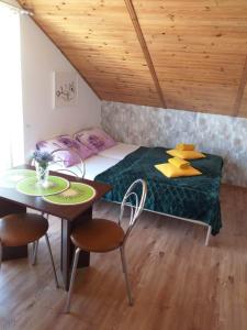 ein kleines Schlafzimmer mit einem Bett und einem Tisch in der Unterkunft Pokoje u Bożeny in Karwia