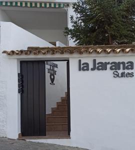 un edificio blanco con puerta y escalera en Casa Hotel LA JARANA, en Zahara de la Sierra