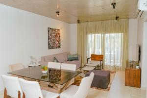 a living room with a glass table and white chairs at Familiar dpto. zona aeropuerto!!! in Asunción
