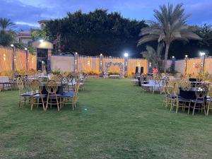 een groep tafels en stoelen in een tuin 's nachts bij فيلا الواحة للحفلات والمناسبات بالعجمي/أبو يوسف in Alexandrië