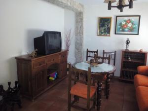 sala de estar con TV y mesa con mesa en Casa Hortensia en Cazorla