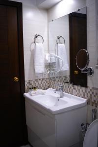 ラホールにあるFaletti’s Grand MM Alam Roadのバスルーム(白い洗面台、鏡付)