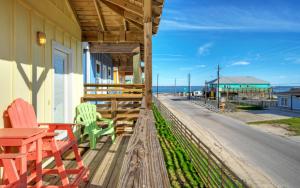 a porch with chairs and a table on a building at Laguna Village Paradise 2 Home Buyout On Water in Padre Island