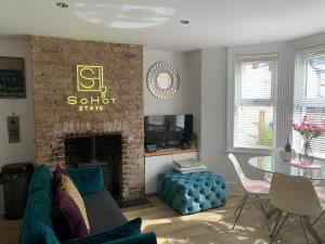 uma sala de estar com um sofá e uma lareira em SoHot Stays Stylish & Cosy with Hot Tub & Log Burner, Margate em Margate