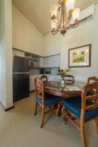 cocina con mesa, sillas y nevera en The Suites of Solymar en Cancún