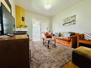 uma sala de estar com um sofá e uma televisão em MRG - Ensolarado 2D - Centro de Gramado em Gramado