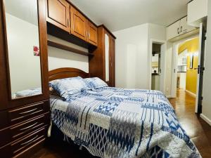 um quarto com uma cama com um edredão azul e branco em MRG - Ensolarado 2D - Centro de Gramado em Gramado