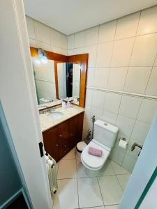 a bathroom with a toilet and a sink and a mirror at MRG - Ensolarado 2D - Centro de Gramado in Gramado
