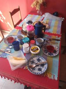 a table with plates of food on it at Casa da Ruthemar-Suite para 2 pessoas in São Sebastião