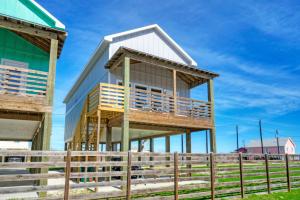a house with a wrap around deck next to a fence at Laguna Village Escape 2 Home Buyout Waterfront in Padre Island