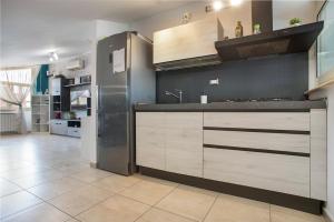 a kitchen with wooden cabinets and a stainless steel refrigerator at DEA SUITE APARTMENT - FIUMICINO ROME AIRPORT 5 Min - in Fiumicino