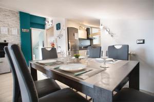 einen Esstisch mit Stühlen und einen langen Tisch mit Weingläsern in der Unterkunft DEA SUITE APARTMENT - FIUMICINO ROME AIRPORT 5 Min - in Fiumicino