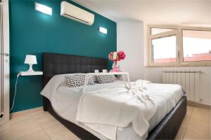 ein Schlafzimmer mit einem großen Bett mit blauer Wand in der Unterkunft DEA SUITE APARTMENT - FIUMICINO ROME AIRPORT 5 Min - in Fiumicino