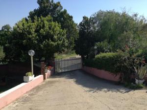 een hek in een tuin met bomen en planten bij domus rosada in Ripa Teatina