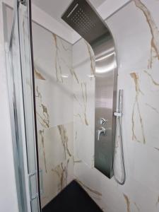a bathroom with a shower with a glass door at Znc Holiday House in Cetara