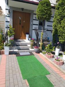 a house with a green lawn in front of a door at Pokoje u Bożeny in Karwia