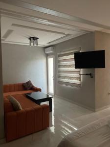 uma sala de estar com um sofá e uma televisão de ecrã plano em Hotel Golden Star em Taounate