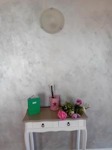 uma mesa com flores e uma caixa verde em Garda City Home Family Apartments em Garda