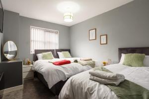 a bedroom with two beds and a mirror at Lovely Getaway Apartment: Two-Bedroom in Rotherham in Rotherham