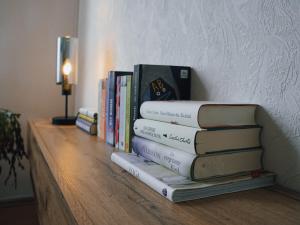 a stack of books sitting on a shelf at Serenity Ferienwohnungen in Gotha in Gotha +12 photos