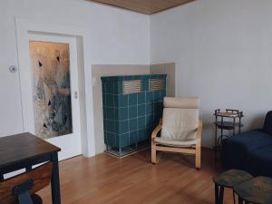 ein Wohnzimmer mit einem Stuhl und einem Sofa in der Unterkunft Serenity Ferienwohnungen in Gotha in Gotha