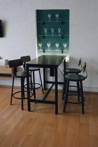 ein schwarzer Tisch und Stühle mit Weingläsern auf einem Regal in der Unterkunft Serenity Ferienwohnungen in Gotha in Gotha