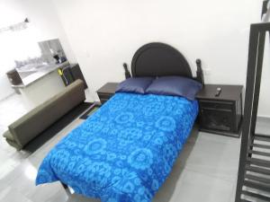 a bedroom with a bed with a blue comforter at Hermoso departamento in Cozumel