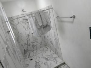 a bathroom with a shower and a white marble wall at Hermoso departamento in Cozumel