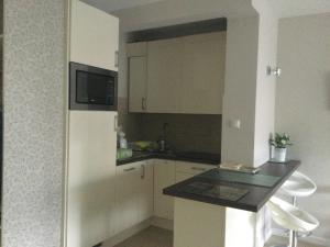 uma cozinha com armários brancos e um balcão preto em Apartament Żagiel em Łukęcin