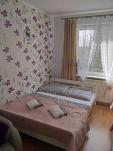 ein Schlafzimmer mit einem Bett mit zwei Kissen darauf in der Unterkunft Pokoje u Bożeny in Karwia
