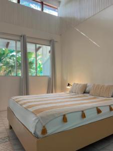 a bedroom with a large bed in a room with windows at Hotel Exotic Lodge in Puerto Viejo