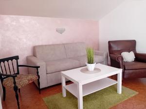 ein Wohnzimmer mit einem Sofa und einem Tisch in der Unterkunft Garda City Home Family Apartments in Garda