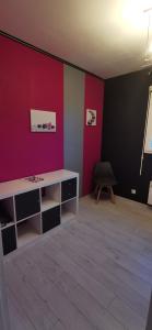 een kamer met een bureau en een rode muur bij Ty Caromel in Cléder