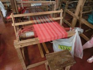 eine hölzerne Plattform mit einer roten Decke darauf in der Unterkunft Balay Tuko Garden Inn in Puerto Princesa