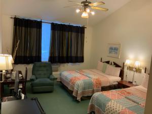 a hotel room with two beds and a chair at Country Lodge Inn in Florenceville